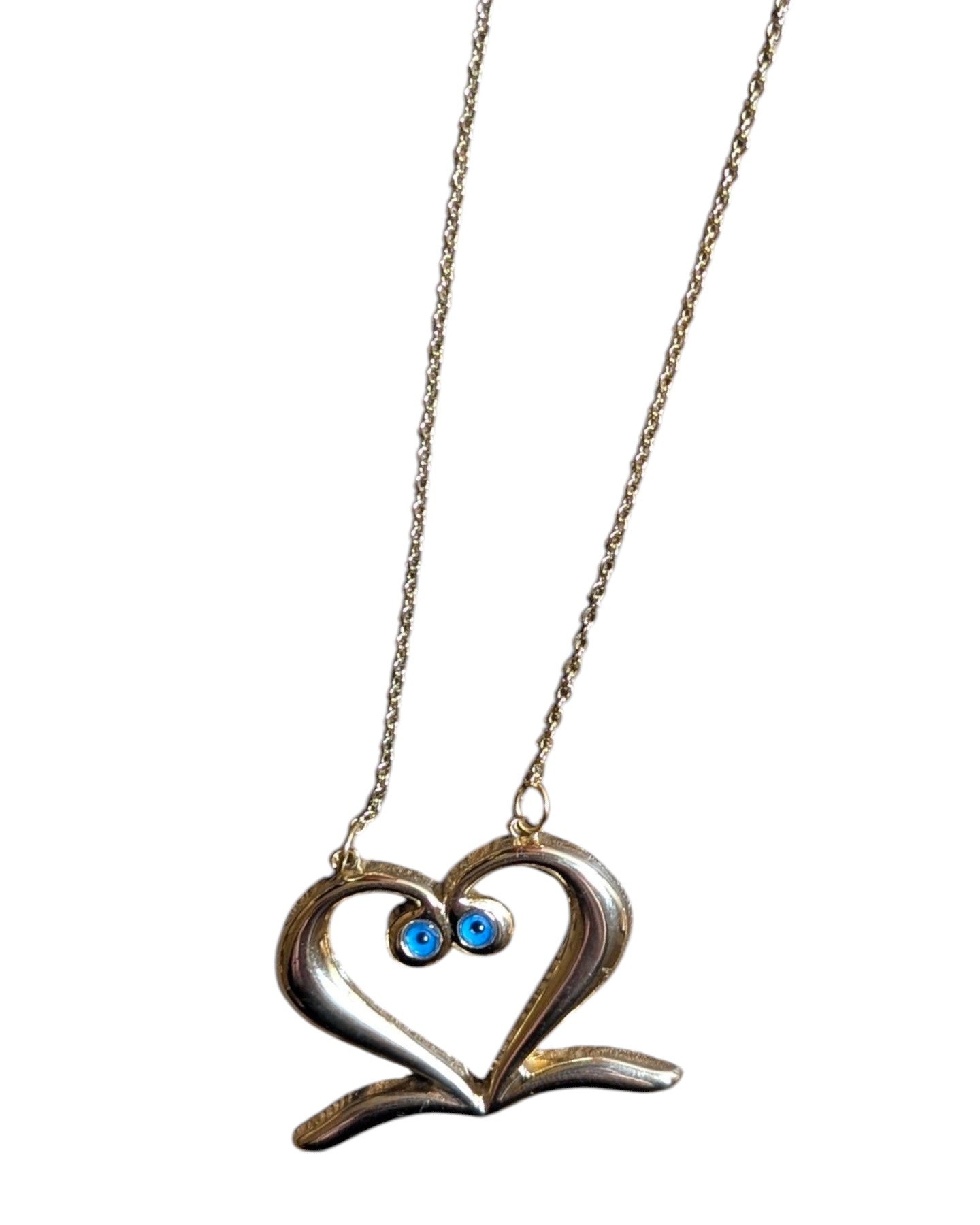 Gold-tone steel heart necklace with two bright blue enamel evil eye accents.