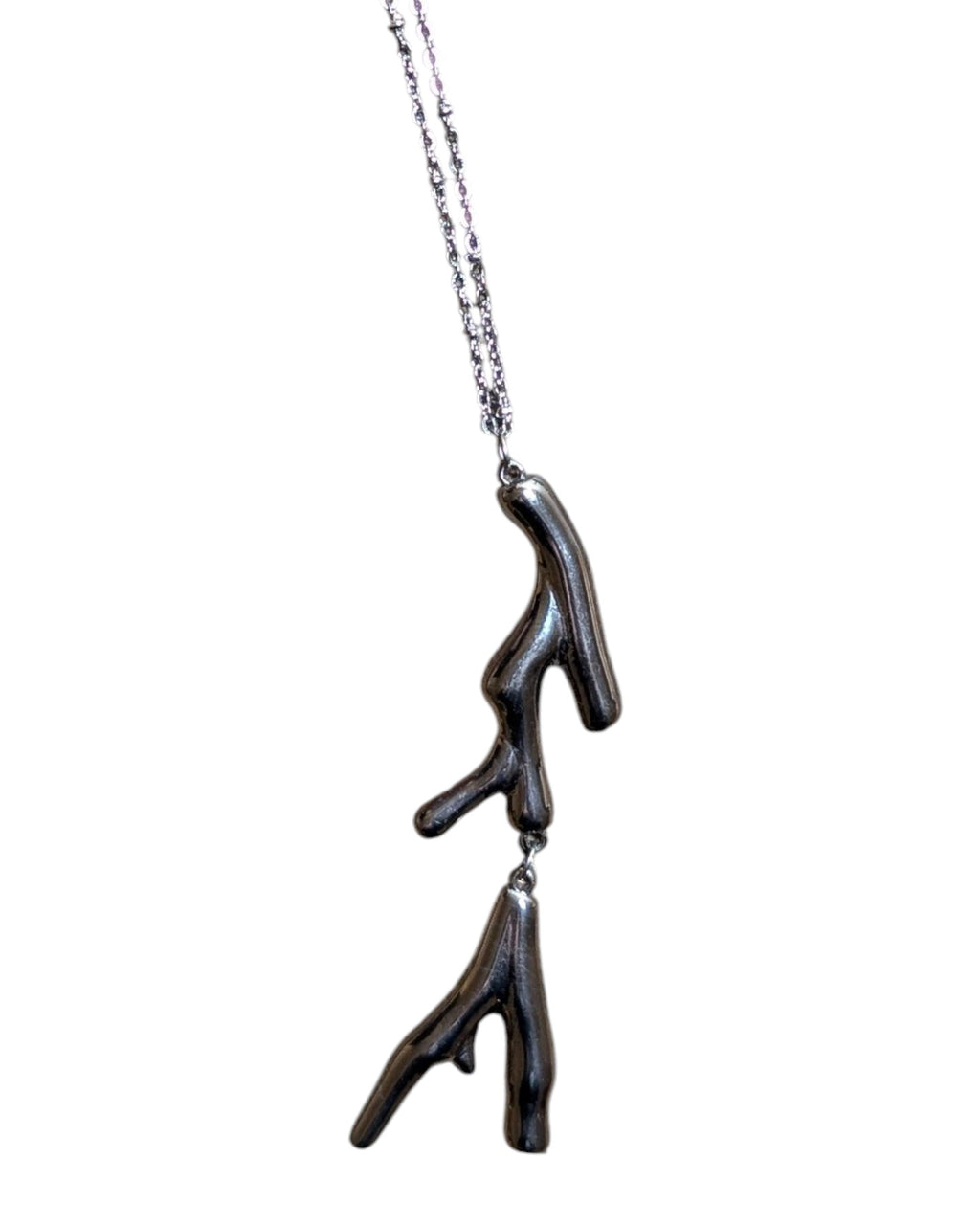 Long silver-tone stainless steel necklace with two-shaped pendants.